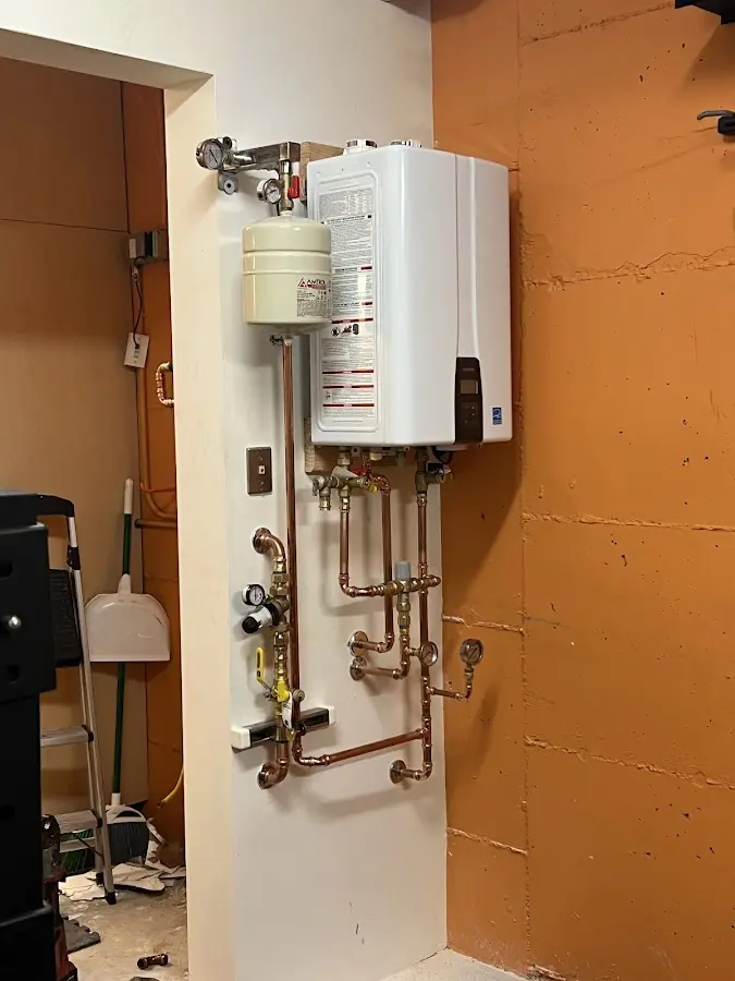 Plumbing technician inspecting water heater connections in Butler